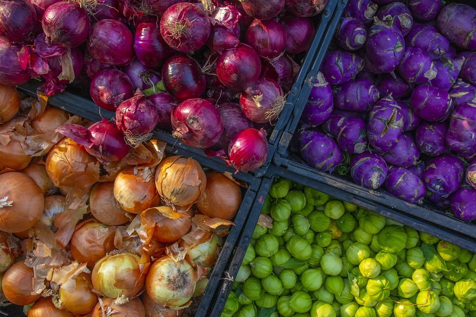 Crates of red and brown onions and limes